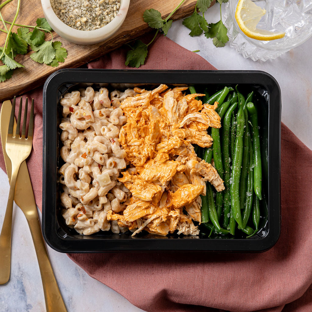 Buffalo Chicken & Mac N Cheese - Tender shredded chicken breast tossed in spicy buffalo sauce, creamy mac n cheese, and green beans